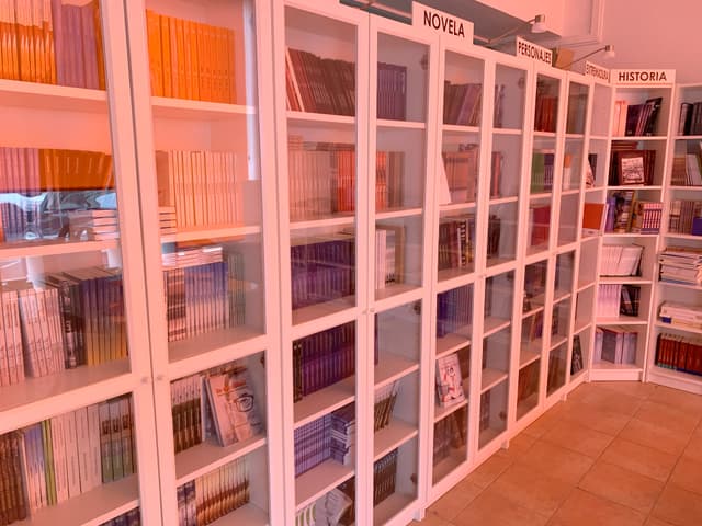 Interior de la editorial Editamás, con las estanterías del catálogo
